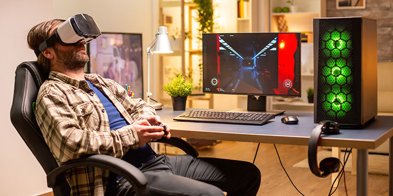Professional gamer man using vr headset to play on powerful pc late at night