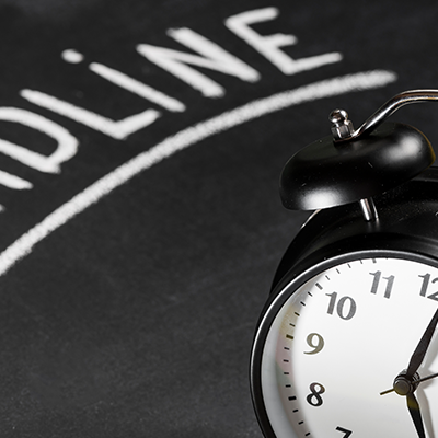 Deadline text written on chalkboard with alarm clock