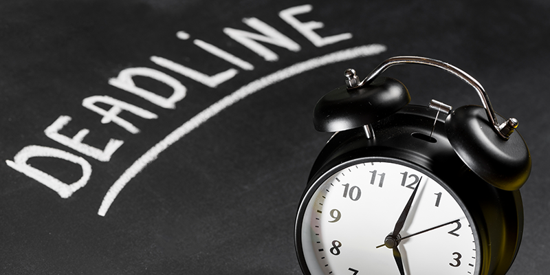 Deadline text written on chalkboard with alarm clock