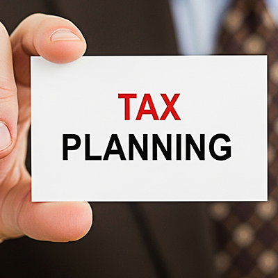 Professional businessman holding a card with the words Tax Planning
